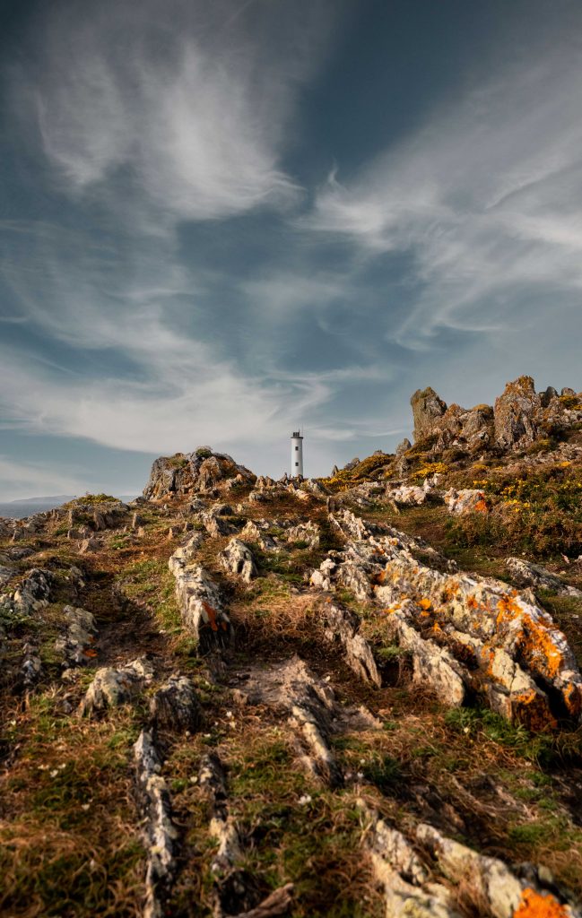 Faro de Cabo Home en atardecer con nubes sedosas